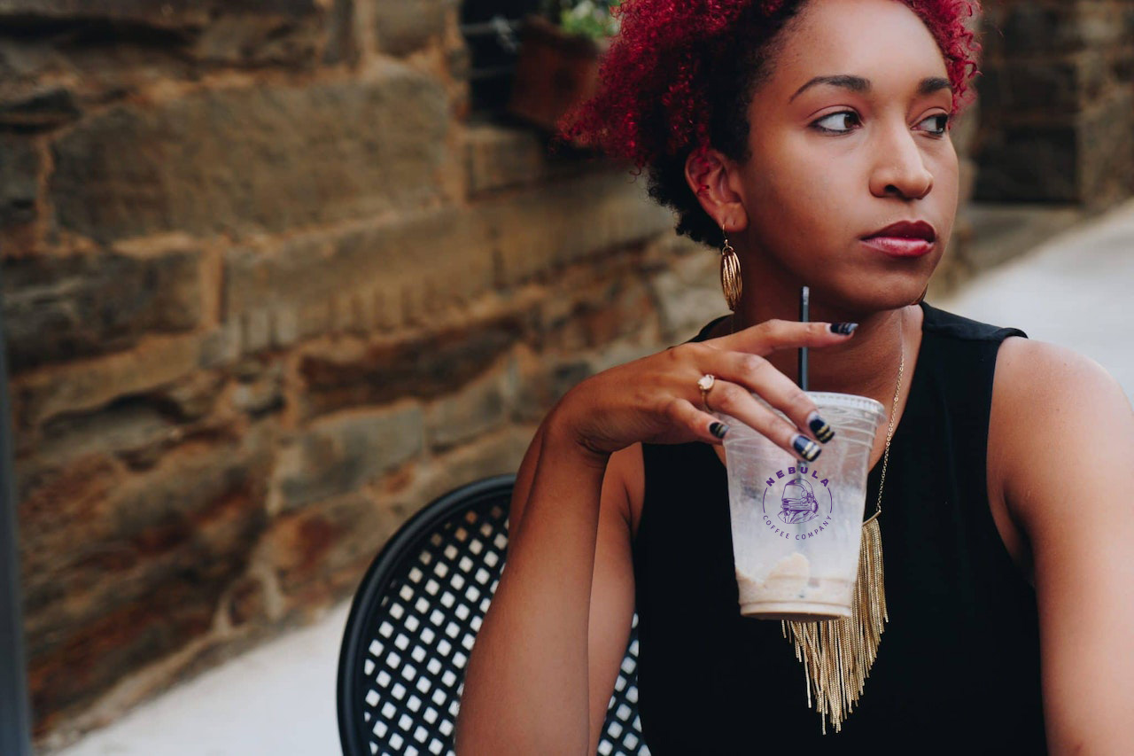 Woman drinking a refreshing iced coffee from Nebula Coffee Company